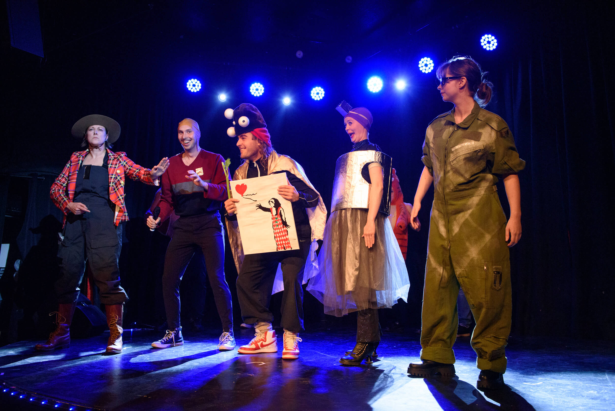 4 performers are dressed as characters from Starfield. In the middle, an audience member is holding a painting and laughing.